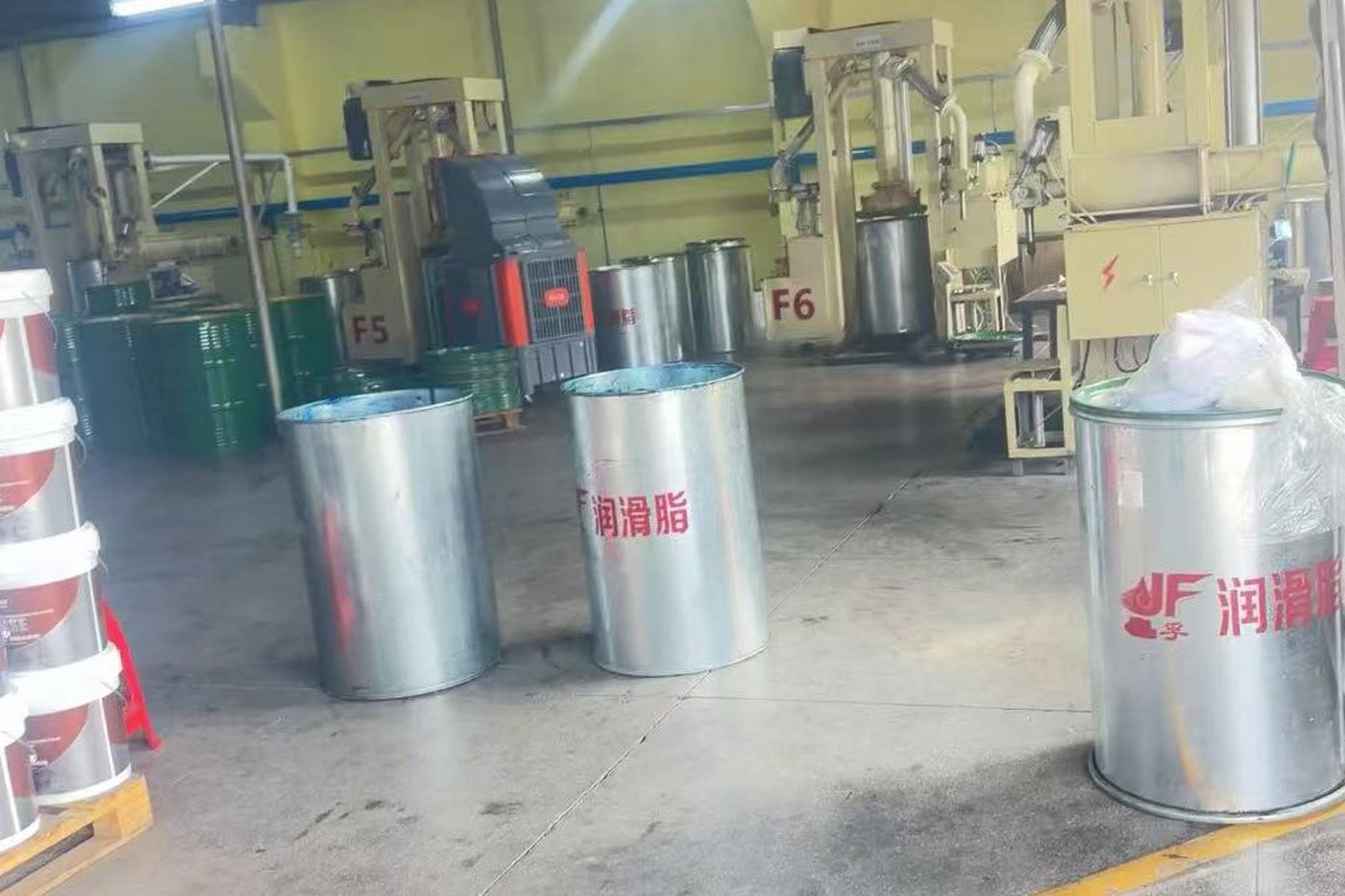 Packed grease drums staged for dispatch with forklifts