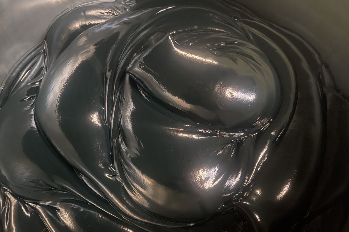 Dark gray calcium grease in open pail