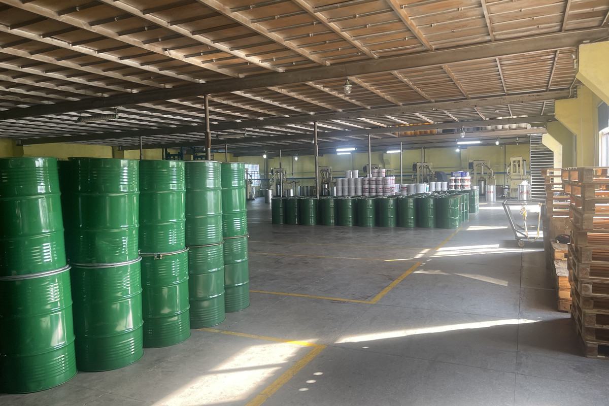 Green 180 kg grease drums stacked in export warehouse
