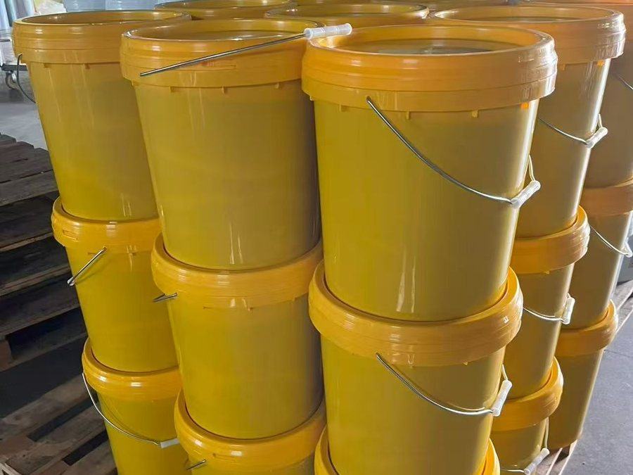 Yellow 15 kg grease pails stacked for export